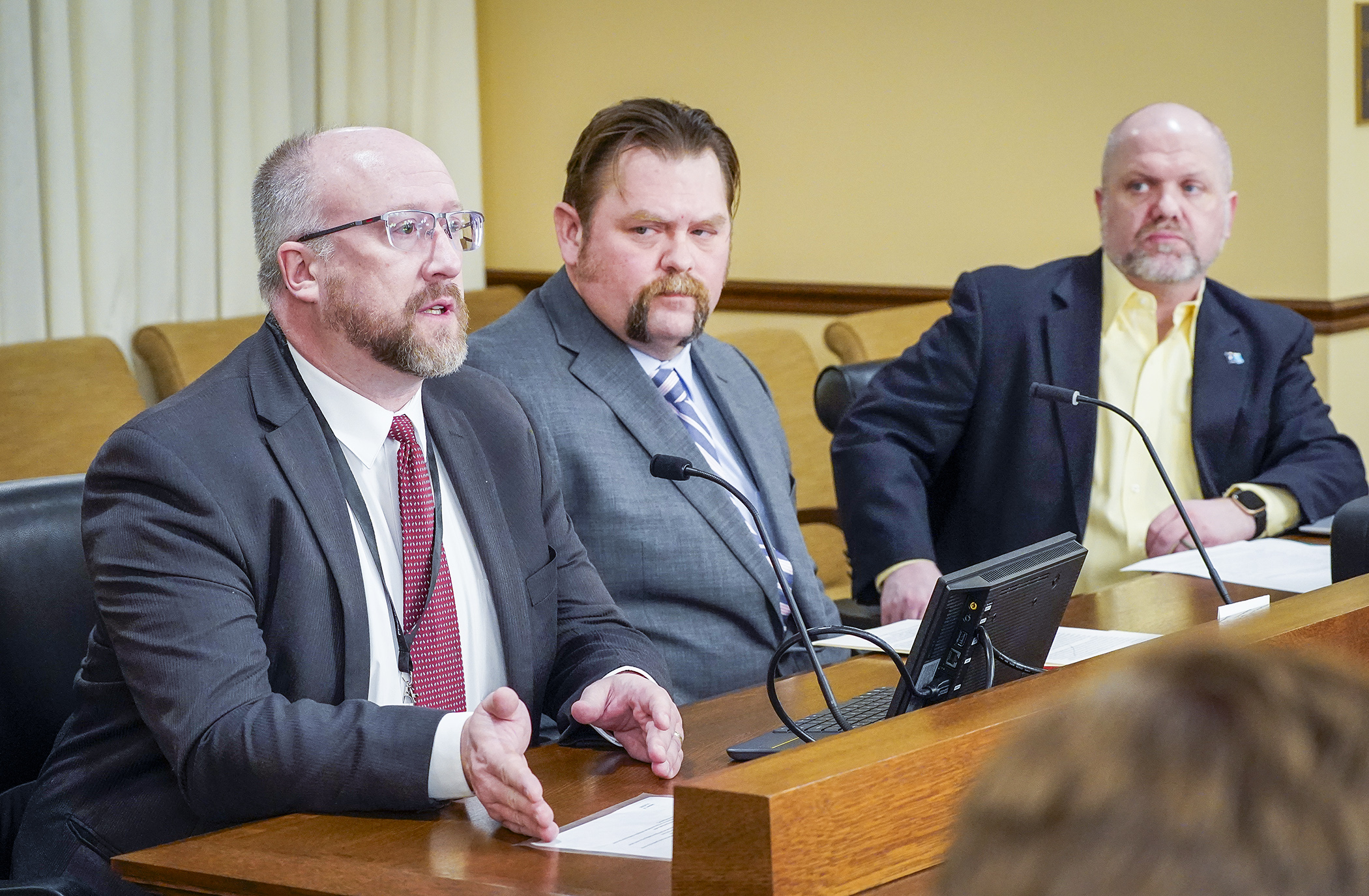 Phil Raines, of the Minnesota Society of Professional Surveyors, and Preston Dowell, center, deputy county surveyor at St. Louis County, testify for HF1478, sponsored by Rep. Mike Freiberg, right, to amend priority criteria for public land survey system monument grant program. (Photo by Andrew VonBank)